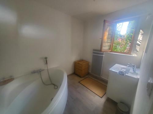 een witte badkamer met een bad en een wastafel bij HAMPTON COTTAGE in Aubry-le-Panthou
