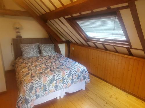 een slaapkamer met een bed in een kamer met een raam bij HAMPTON COTTAGE in Aubry-le-Panthou