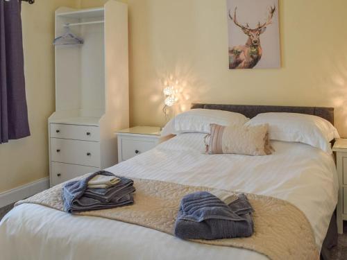 a bedroom with a bed with towels on it at The Old Croft House in Strontian