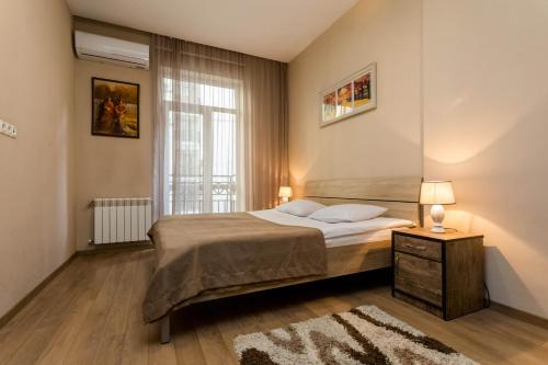 a bedroom with a bed and a window at Central Cosy 5BD-5BATH Apartment in Tbilisi City