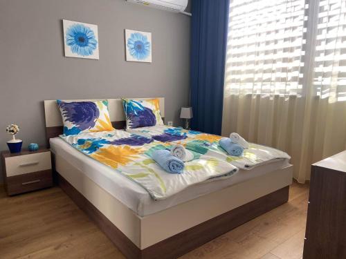 1 dormitorio con 1 cama con toallas en Gardenia Apartment, en Veliko Tŭrnovo