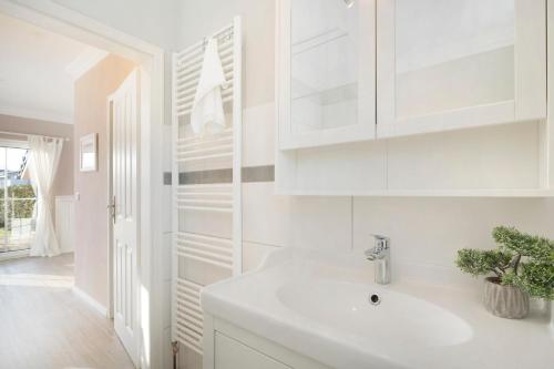 a white kitchen with a sink and white cabinets at Alte Da h me Haus 2 in Dahme