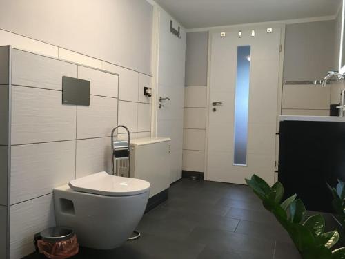 a bathroom with a white toilet and a sink at -Haus am Wäldchen- in Zehdenick