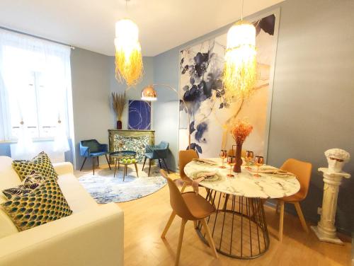 sala de estar con mesa y sillas en Appartements design - Uniques - Centre, en Bagnères-de-Bigorre