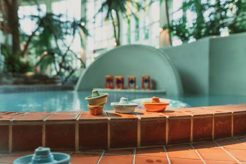 tres tazas sentadas en una mesa junto a una piscina en Holiday Club Katinkulta en Vuokatti