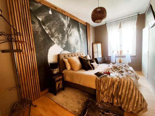 1 dormitorio con 1 cama y una gran pintura en la pared en Appartements design - Uniques - Centre, en Bagnères-de-Bigorre