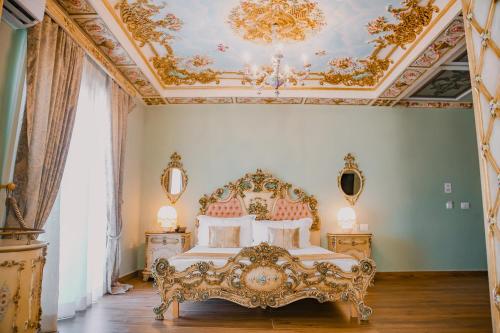 een slaapkamer met een bed met een sierlijk plafond bij Hotel Empire Albania in Durrës