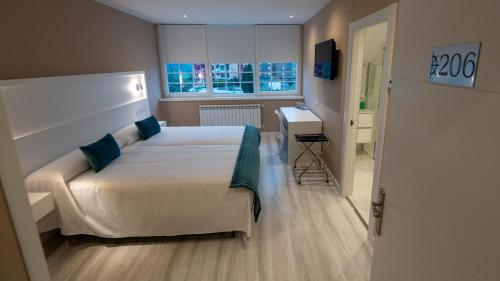 1 dormitorio con cama, escritorio y ventana en Hotel El Parador, en Soto del Barco