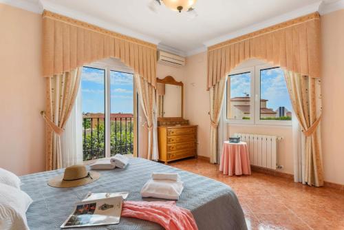 1 dormitorio con 1 cama con sombrero en Villa Serena - PlusHolidays, en Calpe