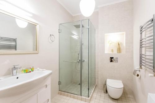 a bathroom with a shower and a toilet and a sink at Central Cosy 5BD-5BATH Apartment in Tbilisi City
