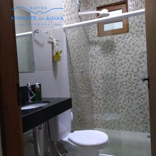 La salle de bains est pourvue de toilettes, d'un lavabo et d'une douche. dans l'établissement Suítes Mirante da Águia, à Ibicoara
