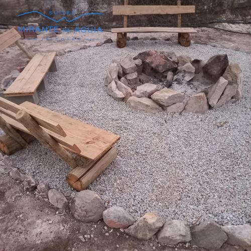 a picnic table and a fire pit with rocks at Suítes Mirante da Águia in Ibicoara