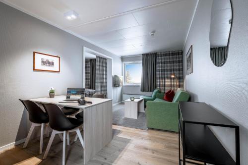 a living room with a table with a laptop on it at Birkebeineren Hotel & Apartments in Lillehammer