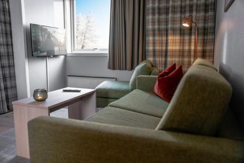 a living room with two chairs and a table at Birkebeineren Hotel & Apartments in Lillehammer