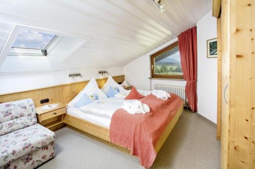 1 dormitorio con cama, ventana y silla en Ferienwohnung Baldauf, en Oberstdorf