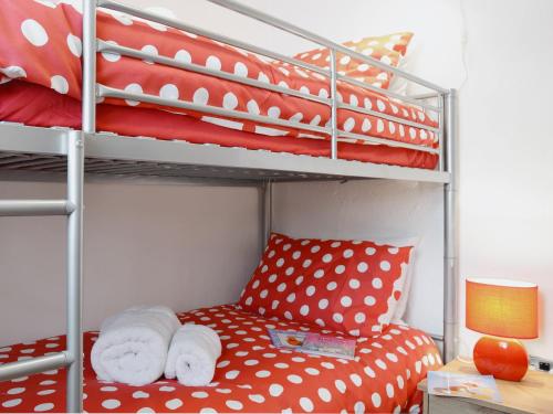 a bunk bed with a red and white polka dot pillow at Kite Cottage in Llandeilo