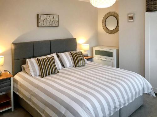 1 dormitorio con 1 cama grande con almohadas a rayas en Spring Cottage, en Parkgate