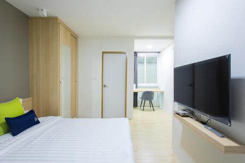 a bedroom with a bed and a flat screen tv at Zayn Express & Suites in Bangkok