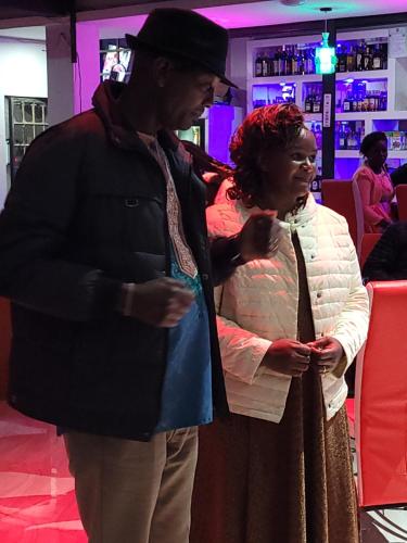 a man and a woman standing in a bar at STERLEON HOTEL RIVERSIDE in Nairobi