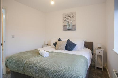 a bedroom with a large bed with blue pillows at Cosy 2-bed home - For Company contractor and Leisure stays - NEC, Airport, HS2, Contractors, Resort World in Marston Green
