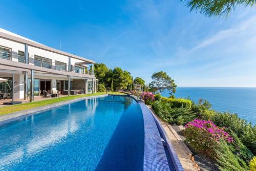 - une piscine en face d'une maison au bord de l'océan dans l'établissement Villa Campomanes - PlusHolidays, à Altea