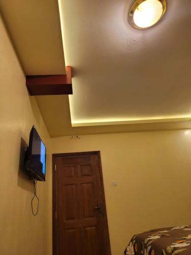 a room with a ceiling with a television and a door at STERLEON HOTEL RIVERSIDE in Nairobi