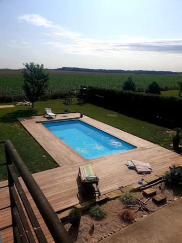 - une piscine dans une cour avec une terrasse en bois dans l'établissement Villa nature - spacieuse et moderne, à Villemer
