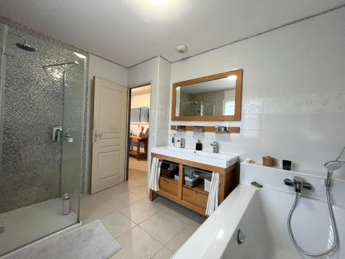 une salle de bain avec une baignoire, un lavabo et une douche dans l'établissement Villa nature - spacieuse et moderne, à Villemer
