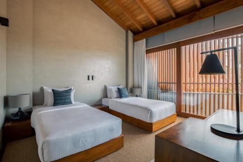 a hotel room with two beds and a window at Villa Thamburu, Bentota in Bentota