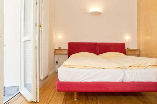 1 cama con cabecero rojo en una habitación en Villa Artemis, 04 Sparta, en Bansin