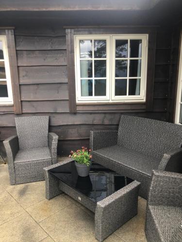 a patio with two chairs and a table and two windows at Hydlahytta Stryn in Stryn