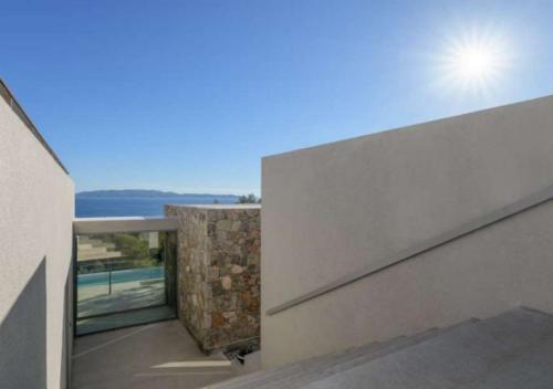 a house with a view of the ocean from a balcony at Villa Alliopi ein Blick für die Sinne in Kranidi