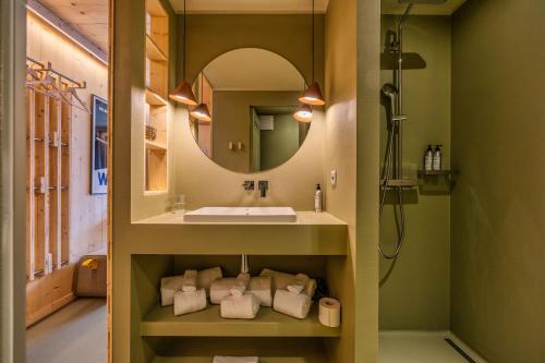 ein Bad mit einem Waschbecken und einem Spiegel in der Unterkunft MAD Mount Hotel & Spa in Nendaz