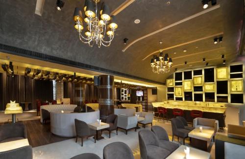 a restaurant with chairs and tables and a chandelier at Udman Hotel Chhattarpur in New Delhi