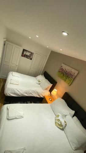 a small room with two beds in a bedroom at Seymour - Marble Arch, Mayfair Apartments hosted by Maysa London in London