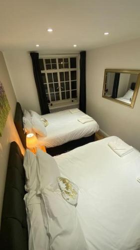 a hotel room with two beds and a window at Seymour - Marble Arch, Mayfair Apartments hosted by Maysa London in London