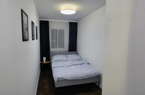 a small bedroom with a bed in a white wall at Siódme Niebo in Wrocław