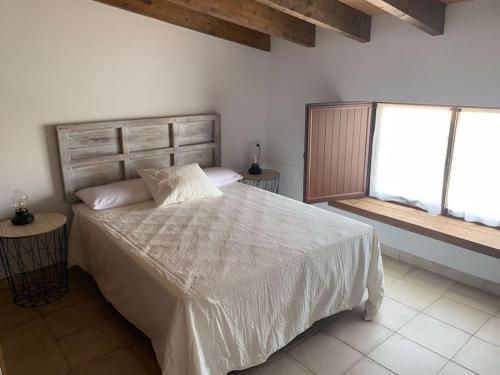赫雷斯－德拉弗龍特拉的住宿－Santa Lucía，一间卧室设有一张大床和一个窗户。