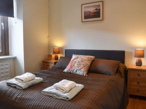 a bedroom with a bed with two towels on it at Gwyrfai Cottage in Waenfawr