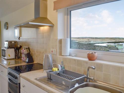 a kitchen with a sink and a window at Hafan in Aberffraw