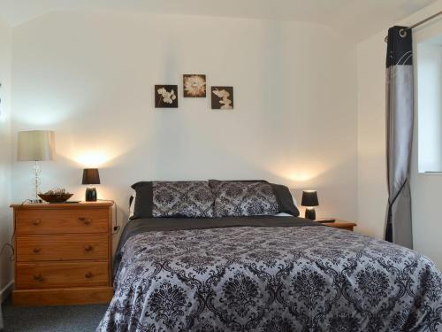 a bedroom with a bed and two pictures on the wall at Hafan in Aberffraw