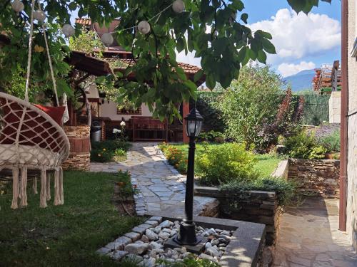 a garden with a lamp post in the yard at Mira Guest House in Dobrinishte