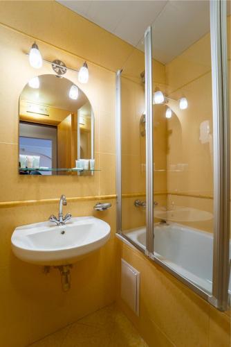 a bathroom with a sink and a shower and a tub at Hotel Halychyna in Ternopilʼ