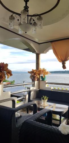 a patio with a table and chairs and the ocean at La Casa de Samonteza in Camotes Islands