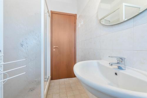 een witte badkamer met een wastafel en een spiegel bij Appartamento 34 in Toscolano Maderno