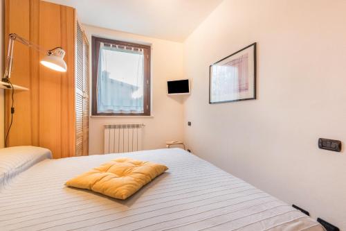 een bed met een geel kussen erop bij Appartamento 34 in Toscolano Maderno