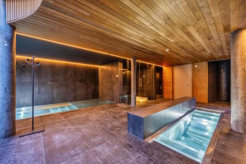 MAD Mount Hotel & Spa في نينداز: حمام مع حوض استحمام ساخن ودش