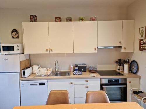 a kitchen with white cabinets and a sink at Gite avec piscine La Buissiere - Fernelmont in Pontillas