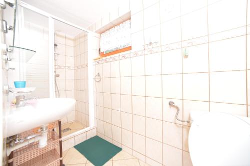 a white bathroom with a sink and a mirror at Domki przy plaży - Pod Wydmami in Dźwirzyno