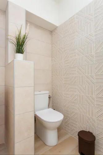 a bathroom with a toilet and a plant on the wall at Tsimiski #apartment (one bedroom) in Thessaloniki
